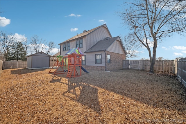 back of property with a playground and a storage unit