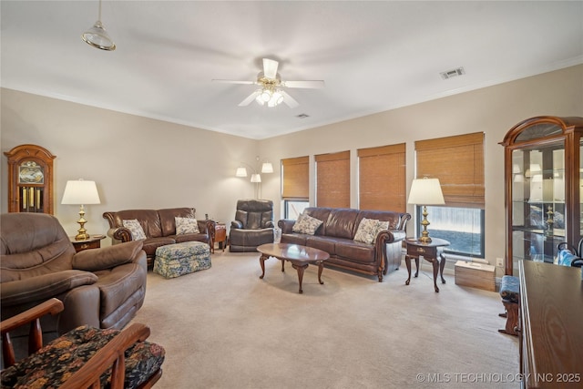 carpeted living room featuring crown molding and ceiling fan