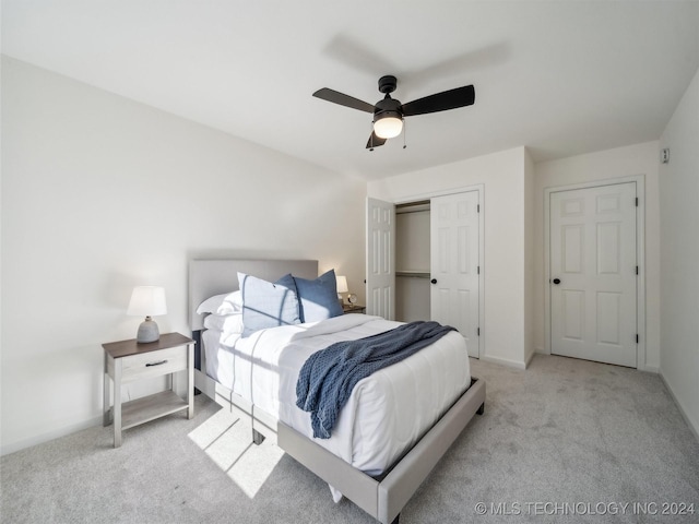 carpeted bedroom featuring ceiling fan and a closet