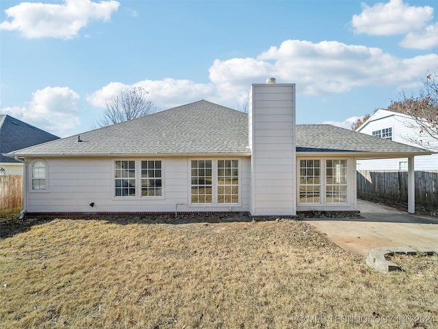 back of house with a lawn and a patio