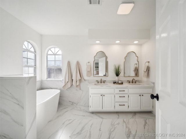 bathroom with a tub to relax in and vanity