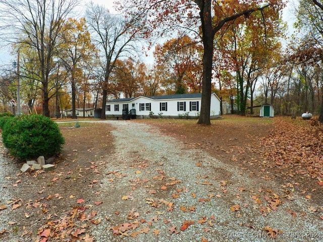 view of front of property featuring a storage shed