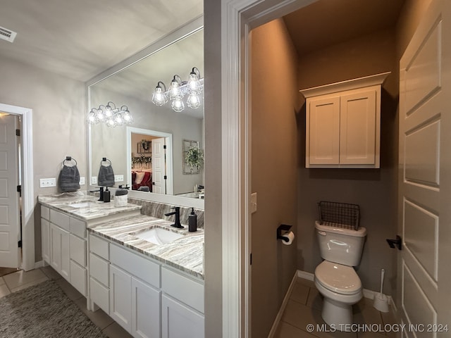 bathroom with tile patterned flooring, vanity, and toilet