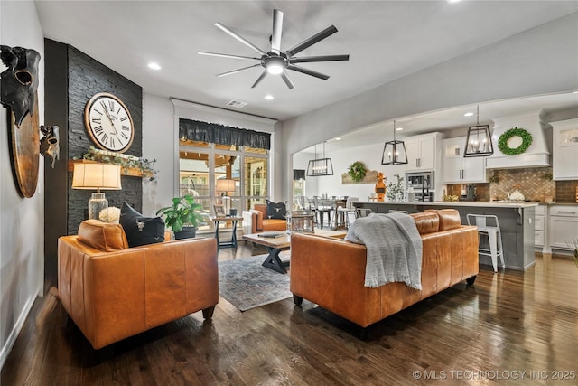 living room featuring ceiling fan and dark wood-type flooring