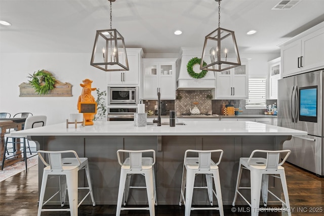 kitchen with a large island with sink, white cabinetry, and appliances with stainless steel finishes