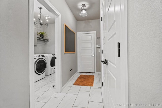 laundry area with a chandelier and washer and clothes dryer