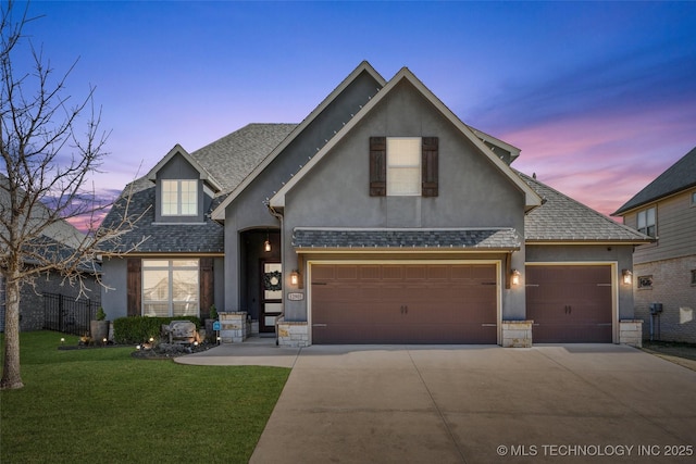 view of front of home featuring a garage and a yard