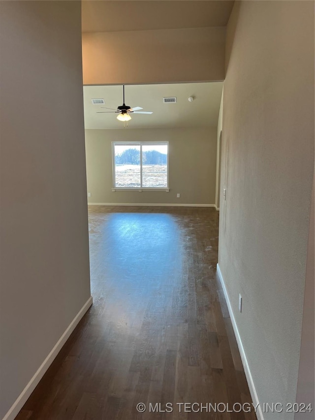 empty room with ceiling fan and dark wood-type flooring