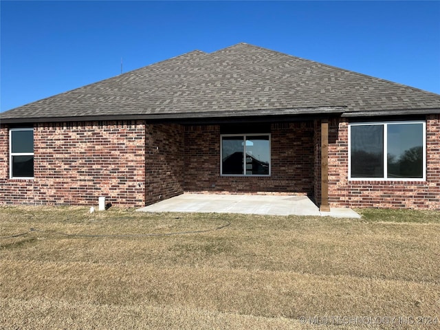 rear view of house with a lawn and a patio area