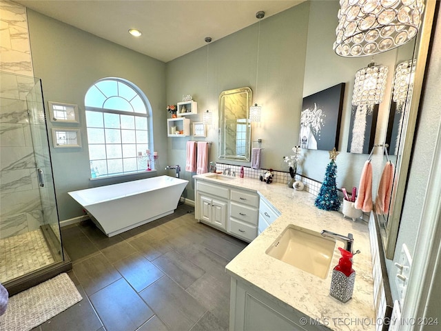 full bathroom featuring a freestanding bath, double vanity, a stall shower, and a sink