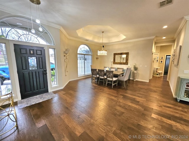 entryway featuring visible vents, a raised ceiling, baseboards, and wood-type flooring