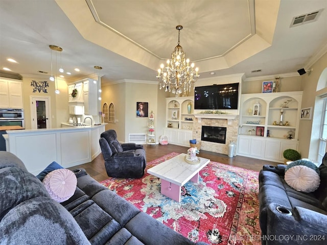 living room featuring a raised ceiling, dark wood-style floors, a fireplace, and visible vents