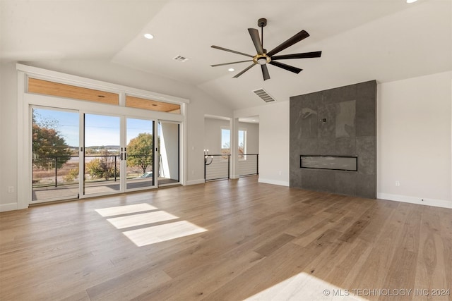 unfurnished living room with a fireplace, light wood-type flooring, vaulted ceiling, and ceiling fan