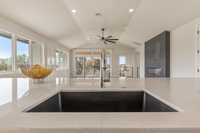 room details featuring a fireplace, ceiling fan, and sink