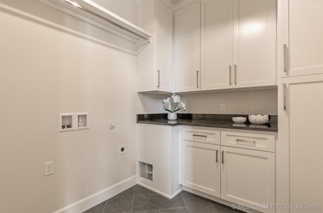 laundry room featuring hookup for an electric dryer, cabinets, dark tile patterned floors, and hookup for a washing machine