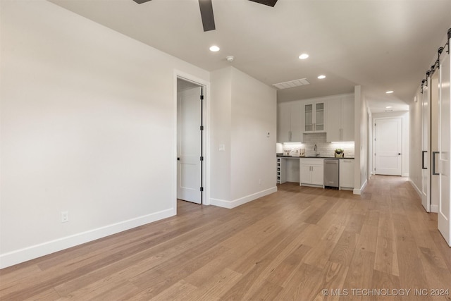 203 E 45th Ct, Tulsa, OK 74105 - unfurnished living room featuring a barn door, ceiling fan, recessed lighting, and light wood-style flooring