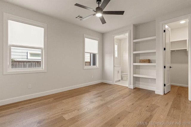 203 E 45th Ct, Tulsa, OK 74105 - unfurnished bedroom with a walk in closet, light wood finished floors, ensuite bath, and a ceiling fan