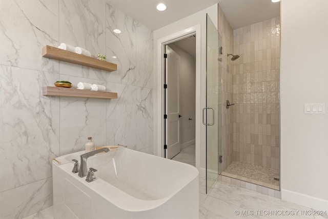 bathroom with separate shower and tub and tile walls