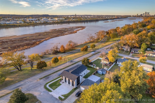 aerial view at dusk featuring a water view