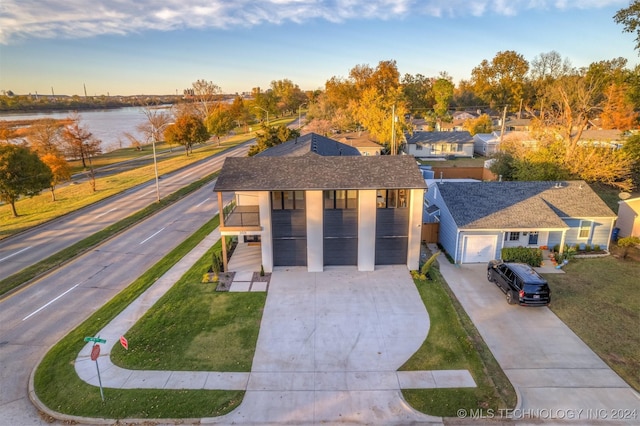 203 E 45th Ct, Tulsa, OK 74105 - modern home featuring covered porch, a front yard, driveway, a water view, and a garage