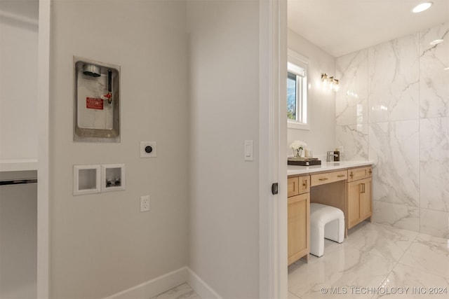 bathroom featuring vanity and tile walls