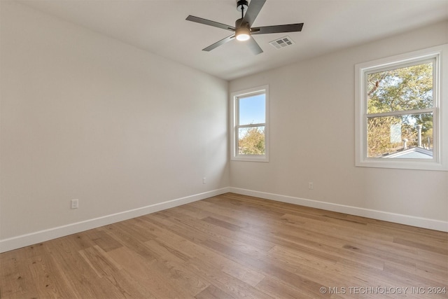 unfurnished room featuring light hardwood / wood-style floors, a wealth of natural light, and ceiling fan