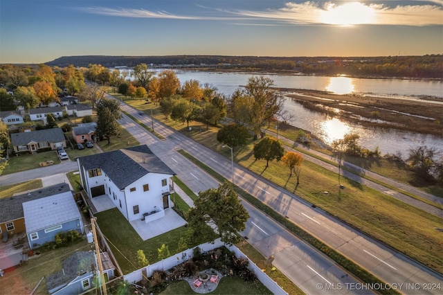 aerial view at dusk featuring a water view