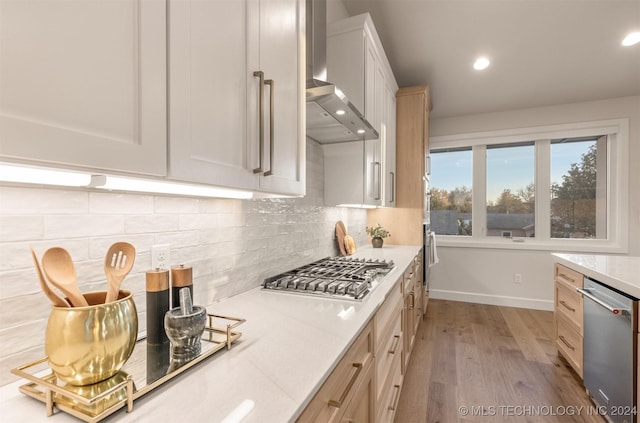 203 E 45th Ct, Tulsa, OK 74105 - kitchen with stainless steel appliances, wall chimney range hood, light wood-style flooring, decorative backsplash, and recessed lighting