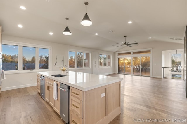 kitchen with light brown cabinets, sink, lofted ceiling, decorative light fixtures, and a center island with sink