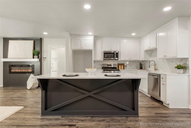 kitchen with backsplash, white cabinets, stainless steel appliances, and dark hardwood / wood-style floors