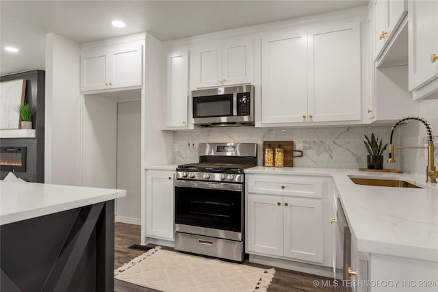 kitchen with white cabinets, stainless steel appliances, dark hardwood / wood-style floors, and sink