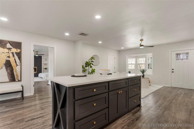 kitchen with a center island, ceiling fan, and dark wood-type flooring