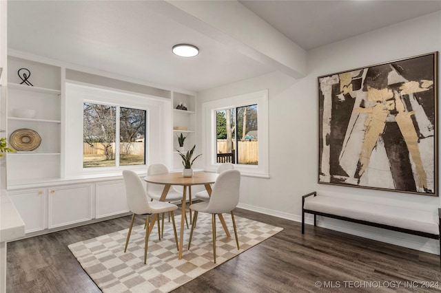 dining room featuring built in shelves and dark wood-type flooring