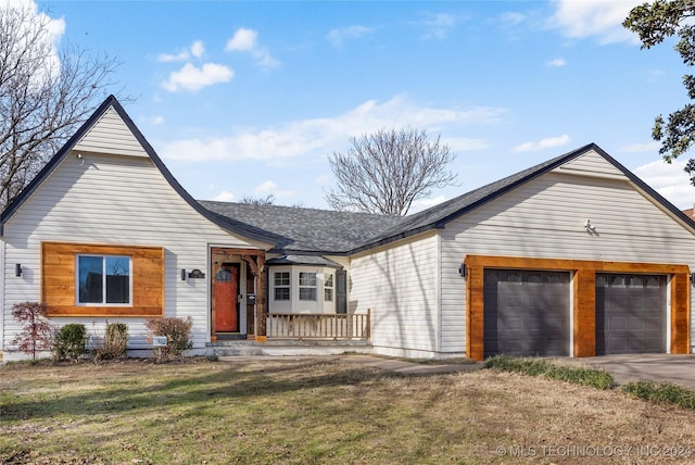 view of front facade featuring covered porch, a garage, and a front lawn