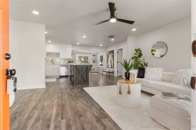 living room with dark hardwood / wood-style floors, ceiling fan, and sink