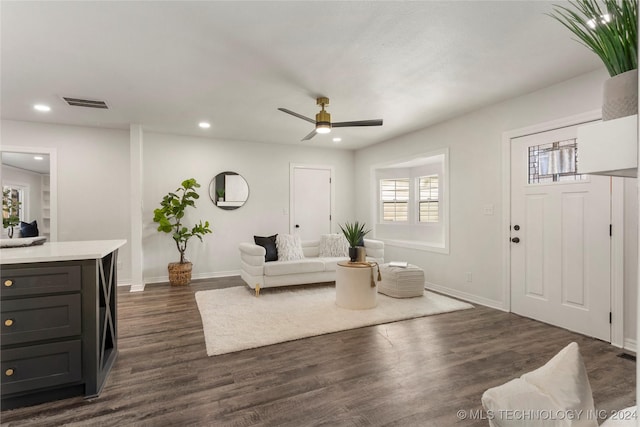 living room featuring ceiling fan and dark hardwood / wood-style flooring