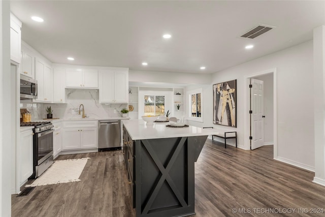 kitchen featuring white cabinetry, sink, dark wood-type flooring, stainless steel appliances, and decorative backsplash