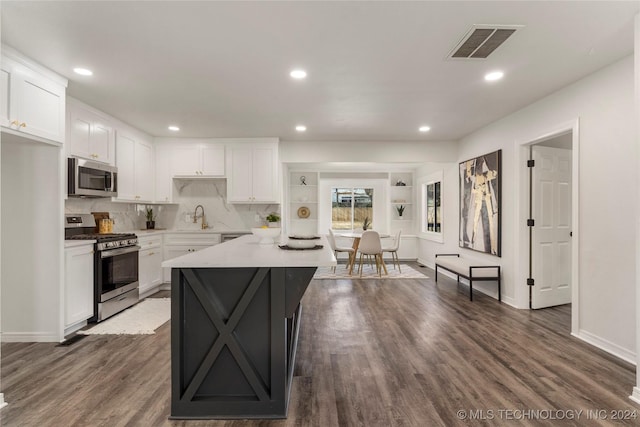 kitchen with white cabinets, stainless steel appliances, and dark wood-type flooring