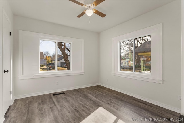 spare room featuring ceiling fan, plenty of natural light, and dark hardwood / wood-style floors