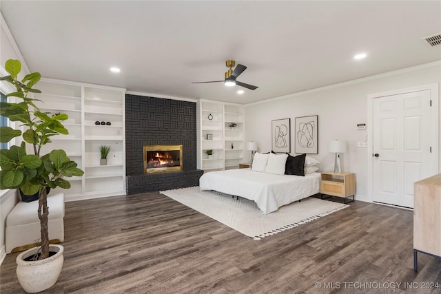 bedroom with dark wood-type flooring, a brick fireplace, ceiling fan, and crown molding