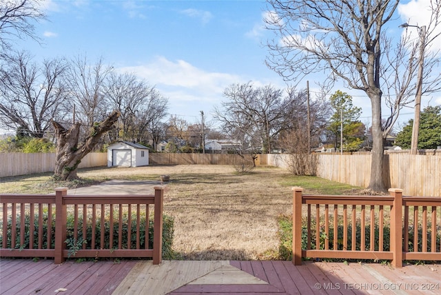 wooden terrace with a storage unit and a lawn