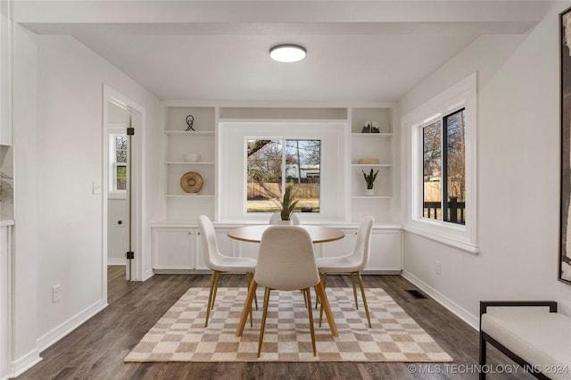 dining area featuring built in shelves and dark hardwood / wood-style floors