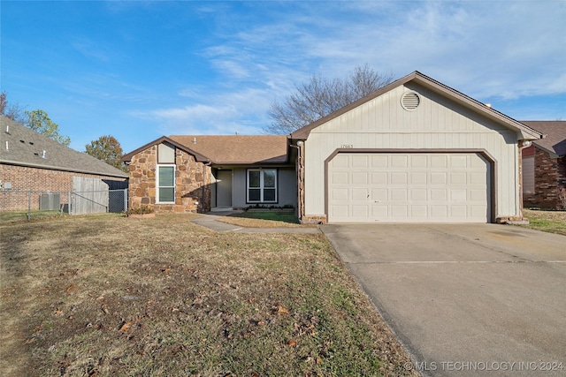 single story home with central AC unit, a garage, and a front lawn