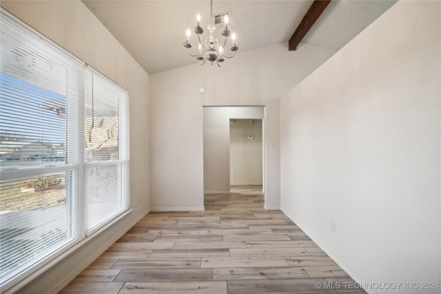 unfurnished dining area featuring lofted ceiling with beams, a healthy amount of sunlight, and an inviting chandelier