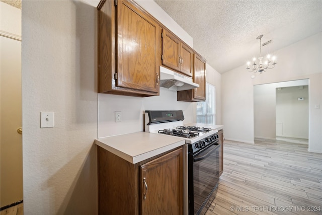 kitchen featuring light wood-type flooring, gas range, a textured ceiling, decorative light fixtures, and lofted ceiling