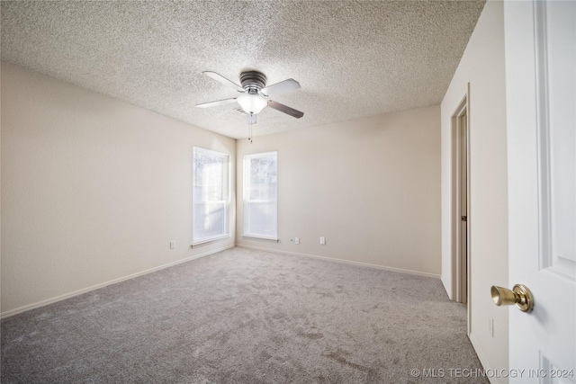 carpeted empty room with ceiling fan and a textured ceiling