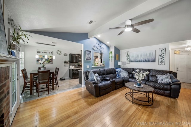 living room with vaulted ceiling with beams, ceiling fan, and wood-type flooring