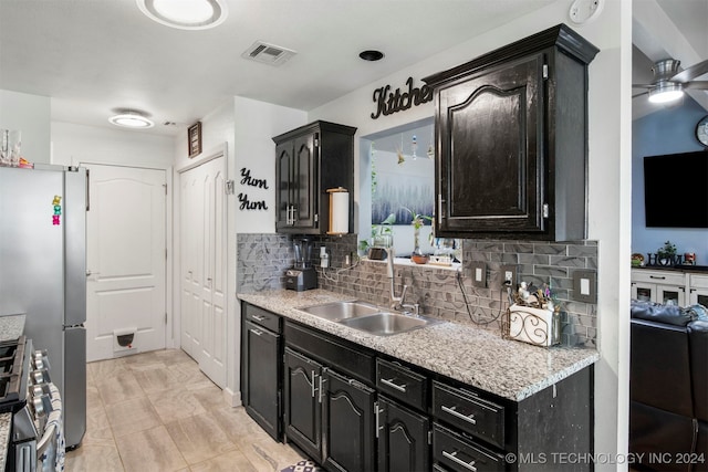 kitchen featuring backsplash, ceiling fan, sink, and stainless steel appliances