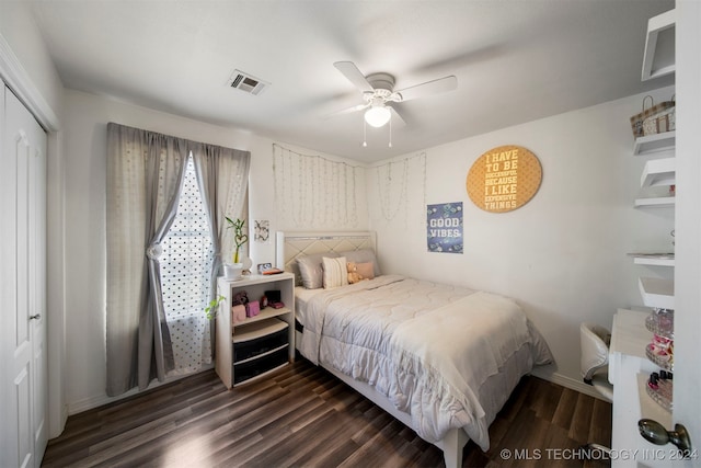 bedroom featuring dark hardwood / wood-style flooring, ceiling fan, and a closet