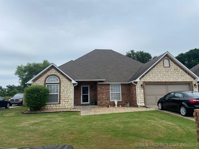 view of front of property featuring a front yard and a garage